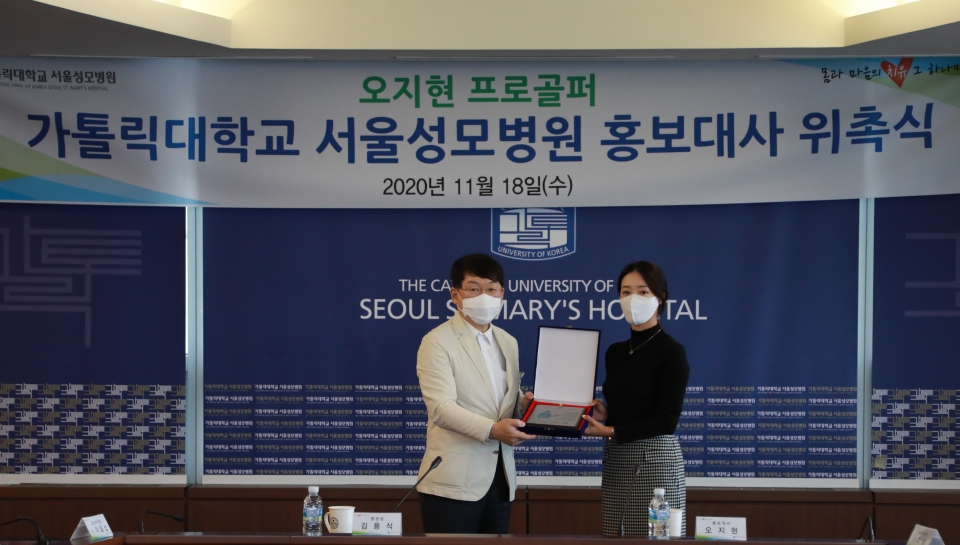 김용식 서울성모병원장(왼쪽)과 오지현 프로골퍼가 18일 병원 21층 대회의실에서 열린 홍보대사 재위촉식에서 기념 촬영을 했다.